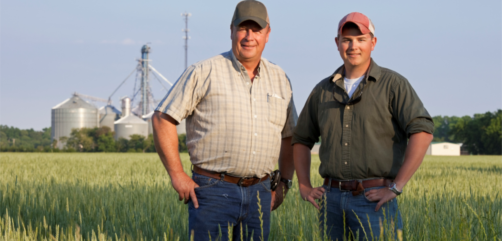 farmer and son in front of farm scene